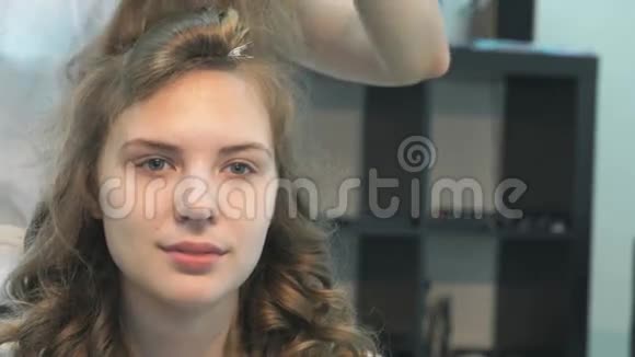 理发师梳着一个漂亮模特的头发视频的预览图