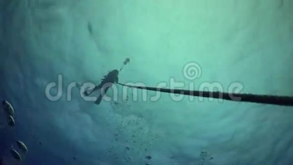 潜水员沿着绳索从深海海底上升视频的预览图