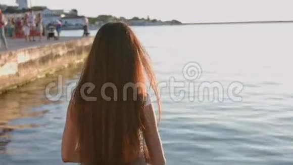 海边穿白裙子的美丽年轻女子的肖像视频的预览图