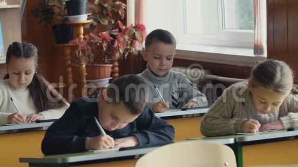 孩子们坐在书桌前写字视频的预览图