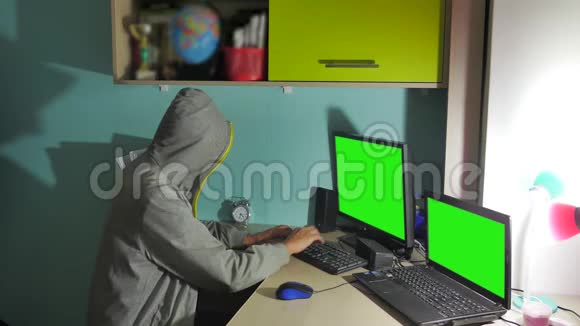 男性黑客在室内电脑上工作一个黑客隐藏了他的脸视频的预览图