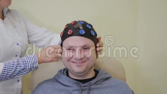 医生给一个人戴上耳机来研究人脑视频的预览图