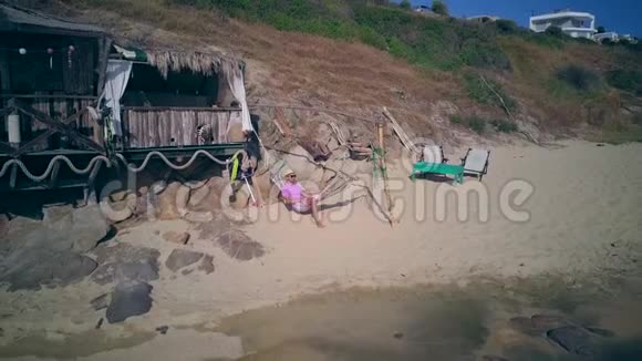 一名男子在吊床上美丽的海滩鸟瞰无人机射击视频的预览图