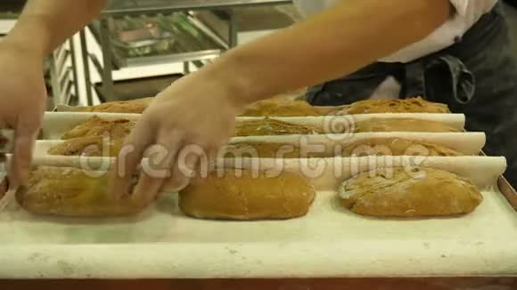 面包师把面团放进一个特制的烤盘里视频的预览图
