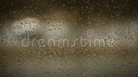 雨滴落在家窗玻璃上有傍晚的交通背景视频的预览图