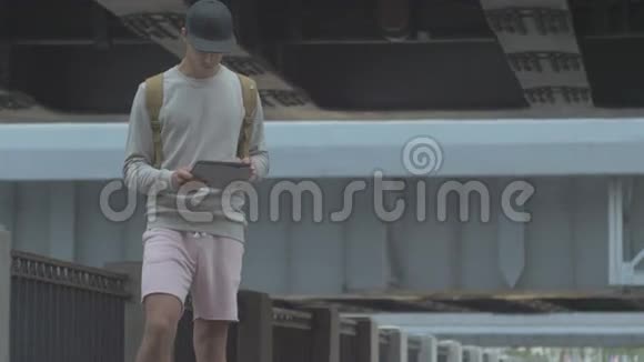 夏天城里的一个年轻人手里拿着一块滑板视频的预览图