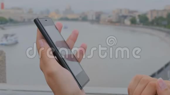 女人在河堤上用智能手机视频的预览图