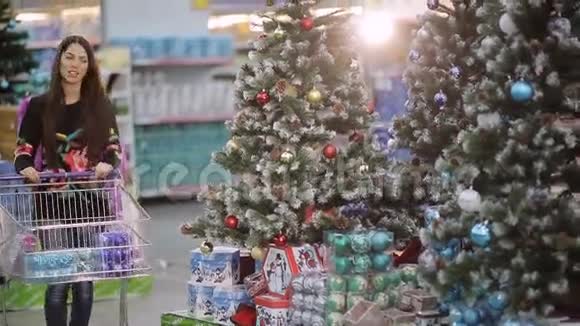 在超市里购物一个年轻的家庭正在超市购物过圣诞节母亲父亲和儿子视频的预览图