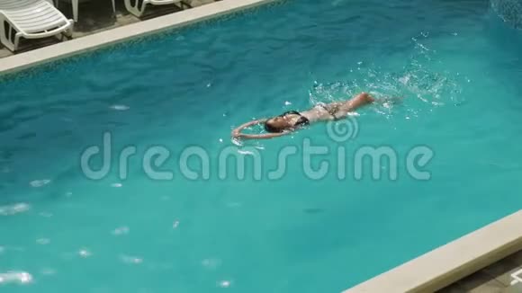 女孩穿着黑色泳衣在酒店的室外游泳池游泳视频的预览图