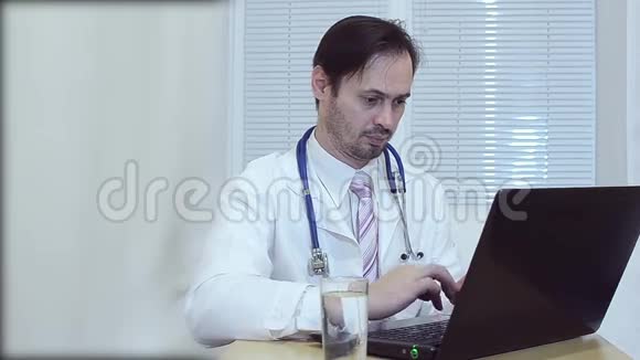 办公室里的医生在用笔记本电脑工作视频的预览图