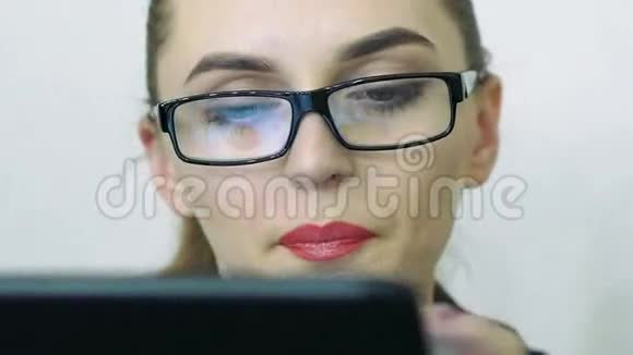 女性面部特写看数码平板电脑屏幕视频的预览图
