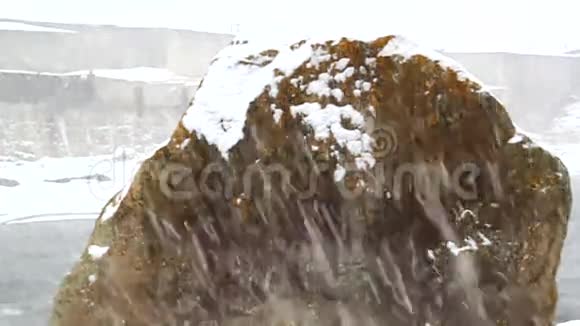 雪在巨大的飞石的背景下雪视频的预览图