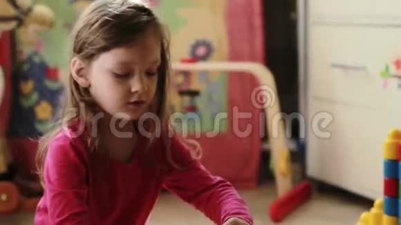 可爱的小女孩在家玩玩具积木视频的预览图