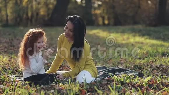 妈妈和女儿在秋天公园玩他们吃笑笑慢动作视频的预览图