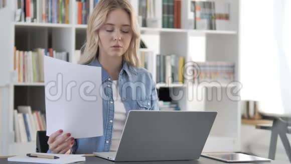 从事文件和笔记本电脑工作的年轻妇女视频的预览图