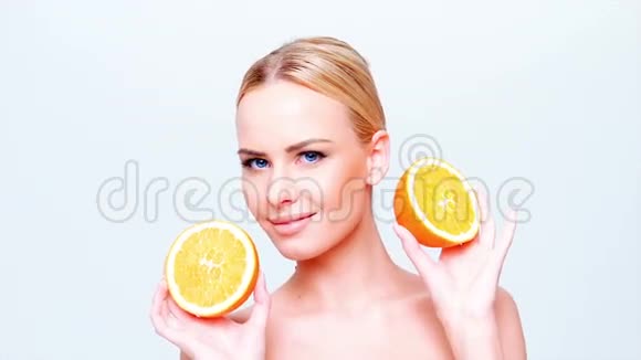 可爱的金发女孩拿着橘子水果视频的预览图