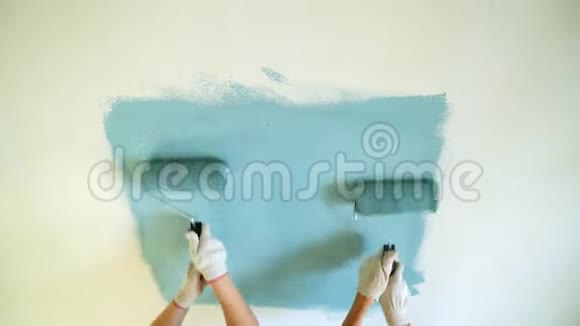 两名女工用滚筒在公寓或房子里粉刷墙壁建设修缮改造视频的预览图