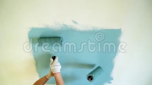 两名女工用滚筒在公寓或房子里粉刷墙壁建设修缮改造视频的预览图