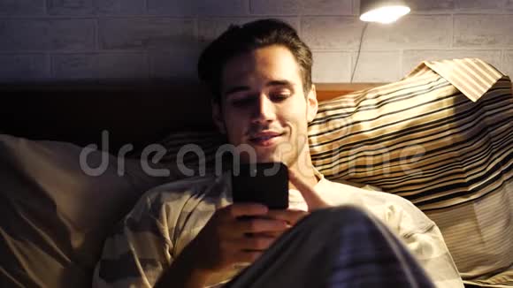在床上打手机的帅哥视频的预览图