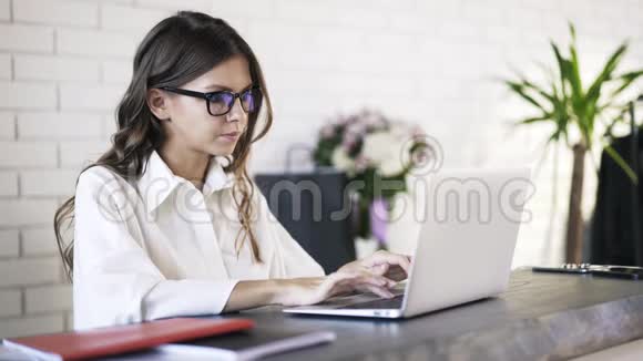 年轻女子在电脑上打字喝咖啡视频的预览图