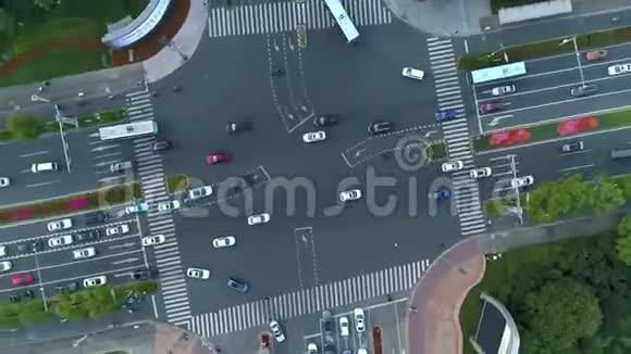 空中无人机在城市的十字路口旋转射击汽车和公共汽车在大道上行驶日落时分视频的预览图