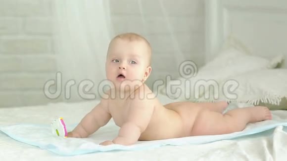 婴儿的肖像六个月大的男孩婴儿躺在床上微笑着视频的预览图