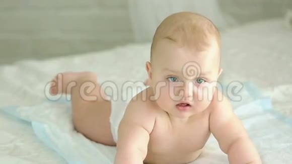 婴儿的肖像六个月大的男孩婴儿躺在床上微笑着视频的预览图