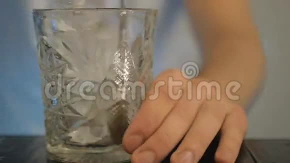 特写镜头那个人把一块冰混在玻璃里视频的预览图