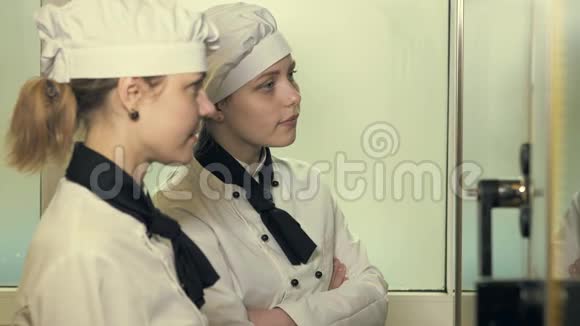 两个厨师女人在厨房里玩视频的预览图