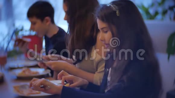 一家群孩子在咖啡馆里吃披萨青少年在咖啡馆里慢动作吃快餐视频的预览图
