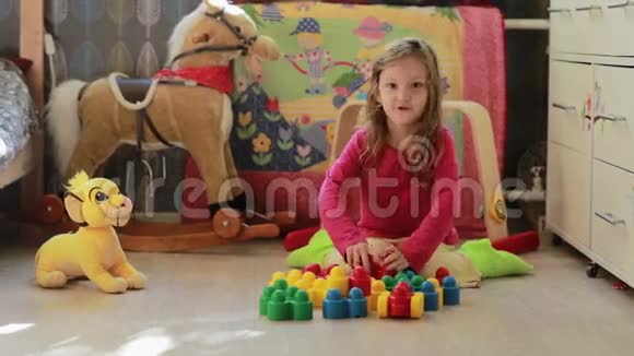 可爱的小女孩在家玩玩具积木视频的预览图