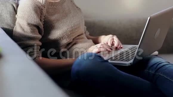 坐在沙发上用笔记本电脑工作的女人视频的预览图