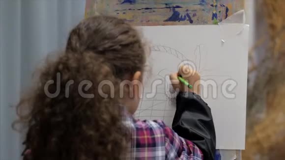 小女孩年轻的艺术家的手小女人艺术家用画笔画一幅画布坐在桌子上画画布视频的预览图
