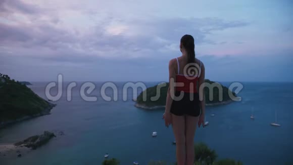 女人在高处练习瑜伽健身运动日出时可以看到令人惊叹的岛屿景观视频的预览图