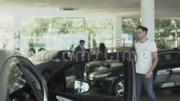 帅哥在汽车经销店检查汽车视频的预览图