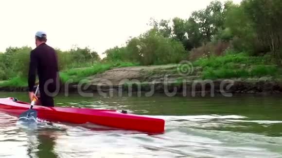 皮艇上的运动划船那个人沿着树林飘下河视频的预览图