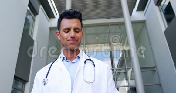 医生拿着数码平板电脑走在走廊里视频的预览图