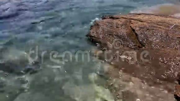 爱琴海清澈的海水冲刷着岩石视频的预览图