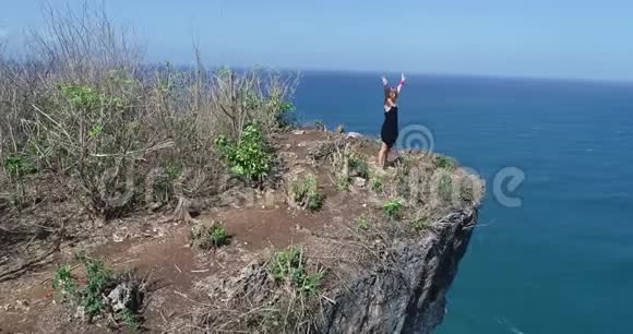 站在美丽悬崖上的少女的鸟瞰图视频的预览图