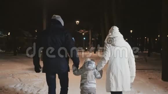 幸福的一家人走在傍晚的冬季公园里视频的预览图