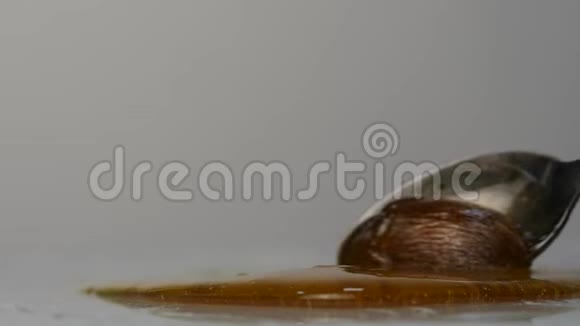 用勺子倒蜂蜜蜂蜜滴在表面慢动作视频的预览图