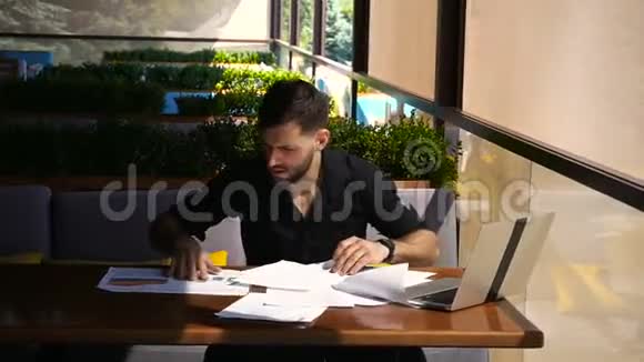 量员在咖啡桌上拿着文件和笔记本电脑工作视频的预览图