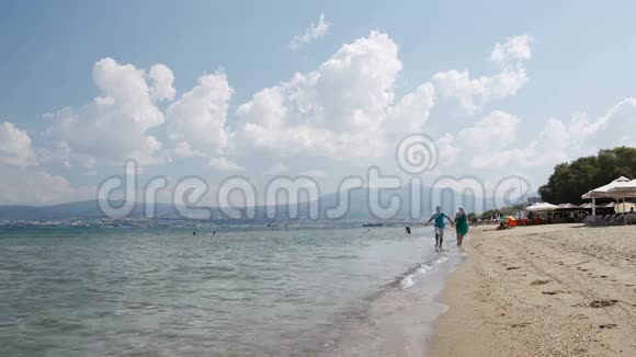 一对年轻夫妇沿着海滩奔跑视频的预览图