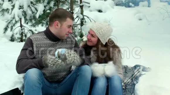 在森林里的男人和女孩在冬天喝茶视频的预览图