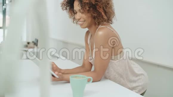 微笑快乐的美国妇女使用个人电脑平板电脑在家里视频的预览图