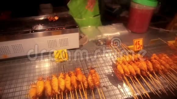 男人买烤鱿鱼在当地市场上出售视频的预览图