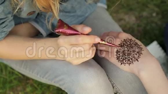 年轻女子用指甲花在一只手上做花视频的预览图