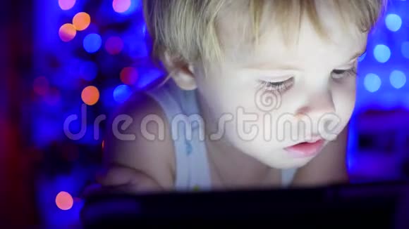 孩子看着躺在床上的药片背景圣诞杉木的灯光和花环视频的预览图