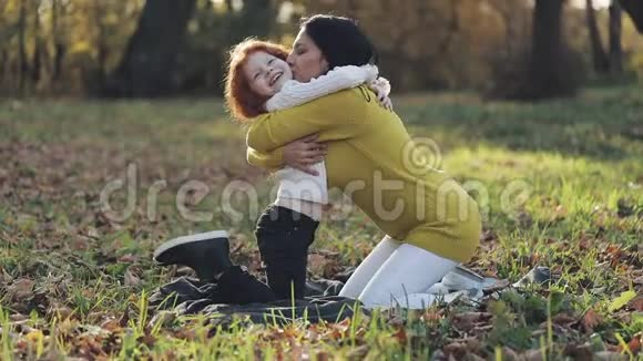 妈妈和女儿在秋天公园玩他们吃笑笑慢动作视频的预览图