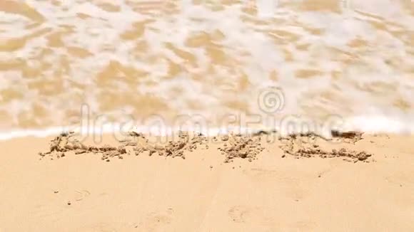 海浪覆盖着爱这个词写在沙滩上视频的预览图